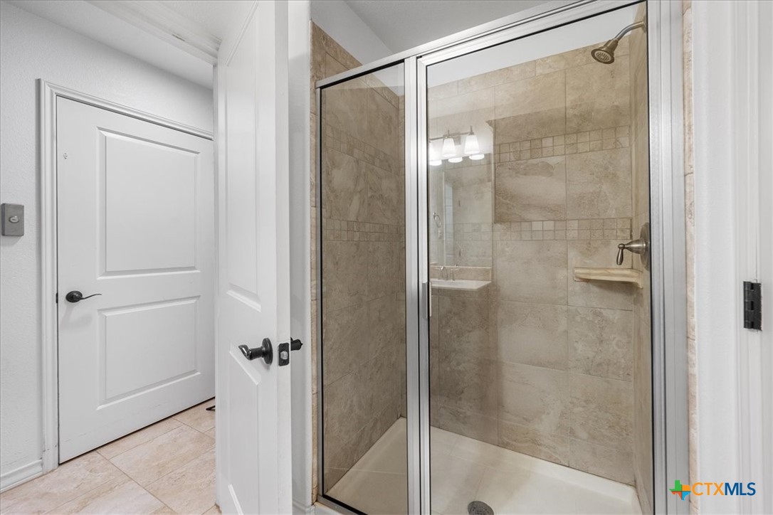 1009 Highknoll Lane Georgetown, TX 78628 - Photo 32 of 38 a bathroom with a glass shower door