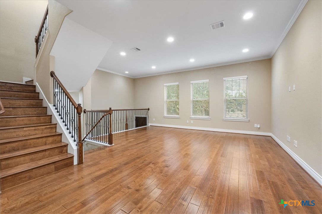 1009 Highknoll Lane Georgetown, TX 78628 - Photo 7 of 38 a view of an empty room with wooden floor and a window