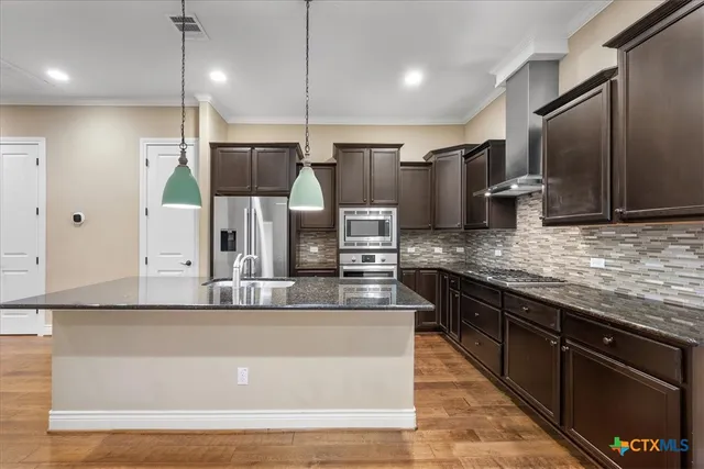 a large kitchen with stainless steel appliances and a counter space