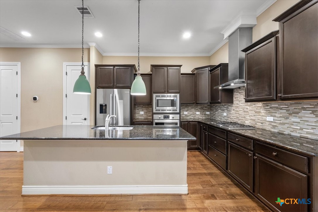 1009 Highknoll Lane Georgetown, TX 78628 - Photo 10 of 38 a large kitchen with stainless steel appliances and a counter space