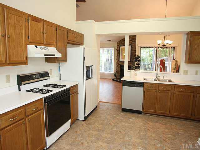 5809 Edgebury Road Raleigh, NC 27613 - Photo 3 of 12 a kitchen with a stove a sink and a refrigerator