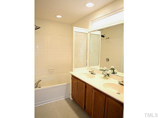5809 Edgebury Road Raleigh, NC 27613 - Photo 9 of 12 a bathroom with a tub sink and mirror