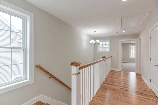 a view of a hallway with wooden floor and windows