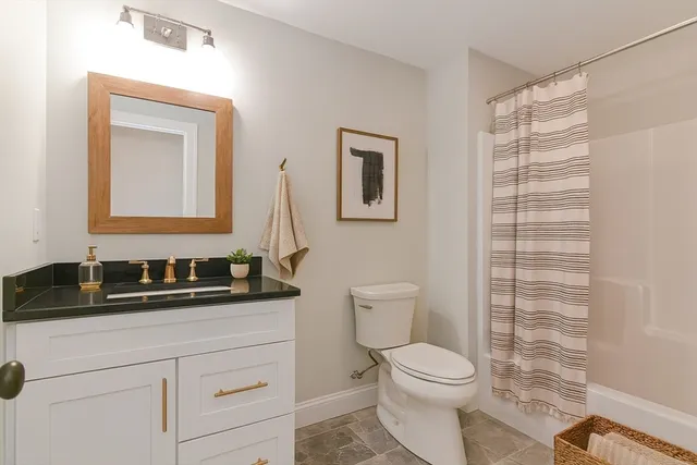 a bathroom with a toilet a sink and mirror