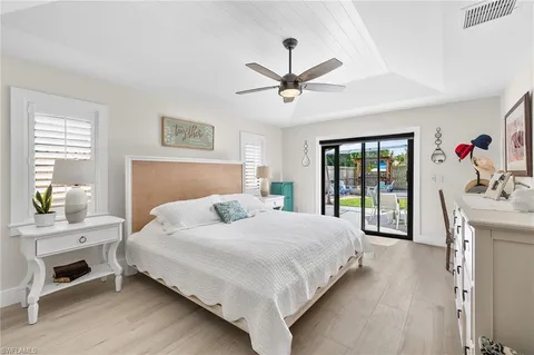 a bedroom with a large bed and a chandelier fan
