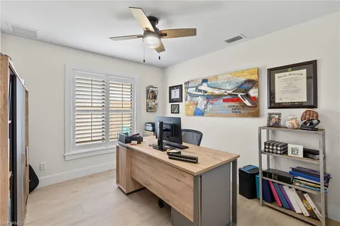 a view of a workspace with furniture and a window