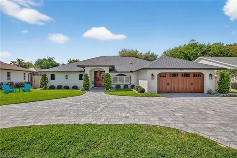 a view of an house with backyard and a tree