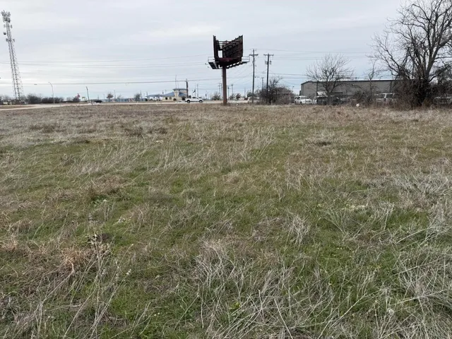 a view of a dry yard with wooden fence