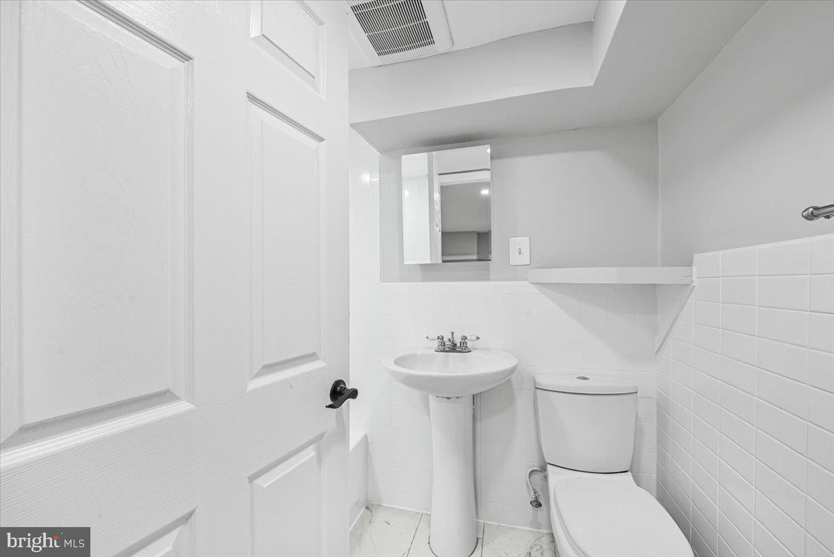 9112 Annapolis Road Lanham, MD 20706 - Photo 30 of 41 a bathroom with a sink toilet and a mirror