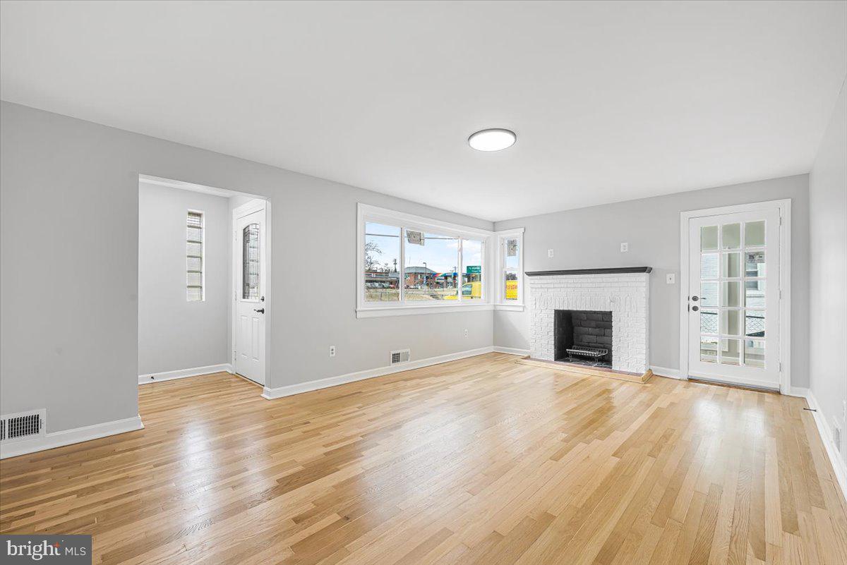 9112 Annapolis Road Lanham, MD 20706 - Photo 6 of 41 a view of empty room with wooden floor and fireplace