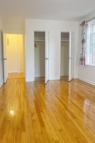 a view of empty room with wooden floor and windows