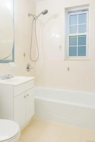 a bathroom with a sink vanity mirror and tub