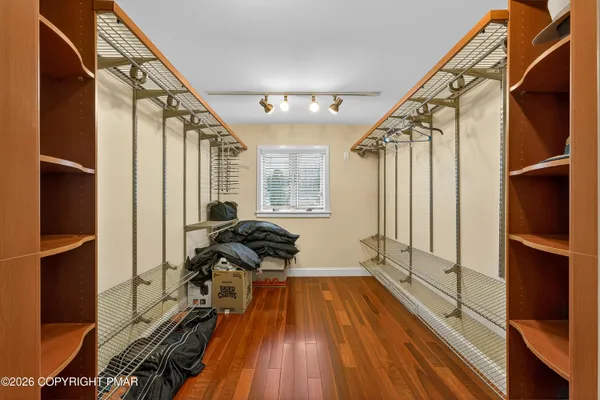 a living room with furniture a flat screen tv and a refrigerator