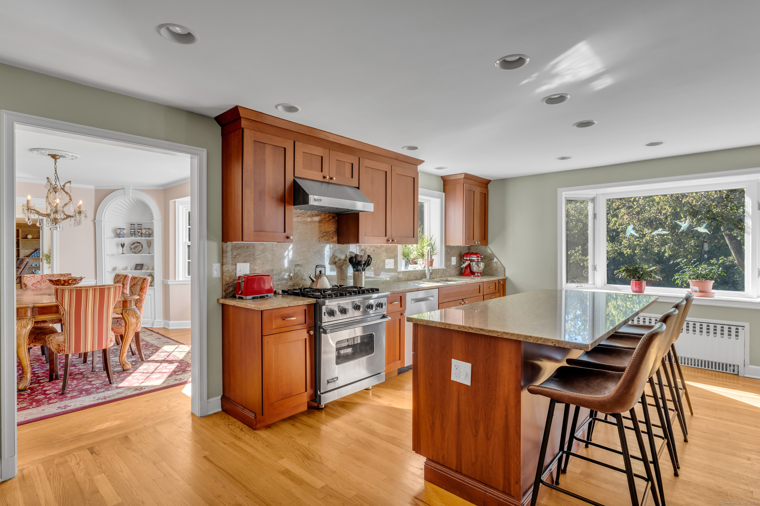 1060 Ridge Road Hamden, CT 06517 - Photo 16 of 40 a kitchen with stainless steel appliances granite countertop a stove top oven a sink dishwasher a dining table and chairs with wooden floor
