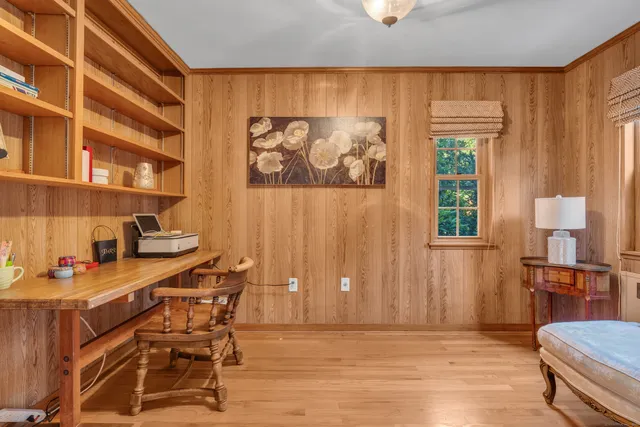 a view of a workspace with furniture and a window