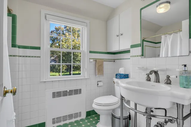a bathroom with a sink a toilet and a window