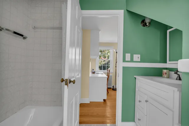 a bathroom with a bathtub sink and mirror
