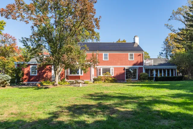 a front view of house with yard and trees in the background