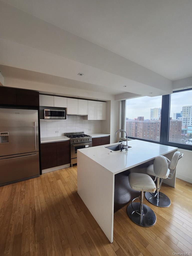 39-16 Prince Street, Unit 9F Queens, NY 11354 - Photo 2 of 8 a large kitchen with a table and chairs
