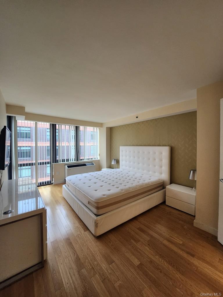 39-16 Prince Street, Unit 9F Queens, NY 11354 - Photo 6 of 8 a spacious bedroom with a bed and large windows