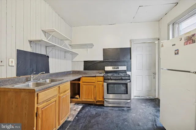 a kitchen with stainless steel appliances granite countertop a sink stove and cabinets