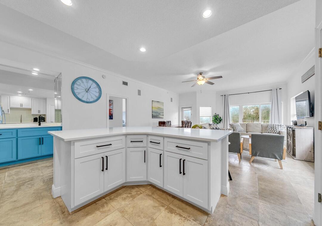 3880 East County Highway 30A, Unit 104 Santa Rosa Beach, FL 32459 - Photo 14 of 49 a large white kitchen with cabinets a sink a stove a dining table and chairs