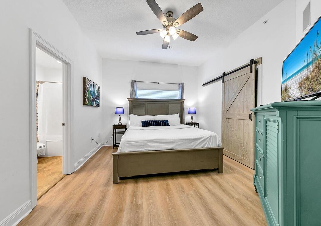 3880 East County Highway 30A, Unit 104 Santa Rosa Beach, FL 32459 - Photo 31 of 49 a bedroom with a bed and a chandelier