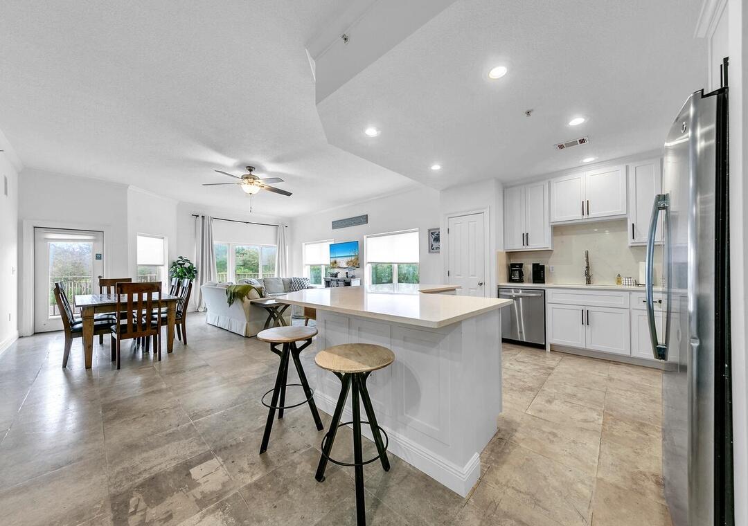 3880 East County Highway 30A, Unit 104 Santa Rosa Beach, FL 32459 - Photo 8 of 49 a kitchen with stainless steel appliances granite countertop a table chairs sink and cabinets