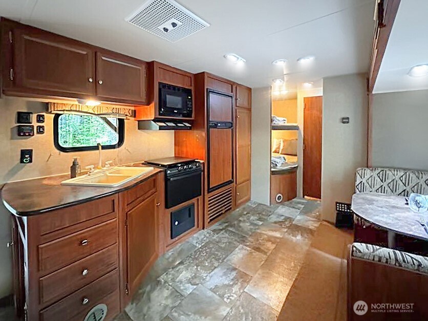 47 Wilderness Way Maple Falls, WA 98266 - Photo 11 of 40 a kitchen with stainless steel appliances kitchen island granite countertop a refrigerator and a stove top oven