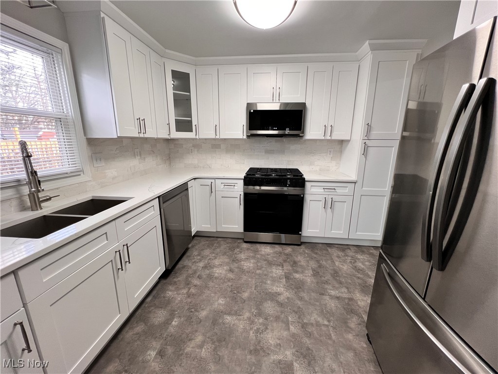 2191 Brockway Road Cleveland, OH 44118 - Photo 4 of 26 Kitchen featuring white cabinets, stainless steel appliances, tasteful backsplash, and sink