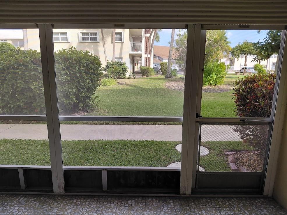 1951 Northeast 39th Street, Unit 127 Lighthouse Point, FL 33064 - Photo 21 of 36 Screened patio out to beautifully maintained gardens, pool, putting green, shuffleboard, bocce, clubhouse and barbecues.