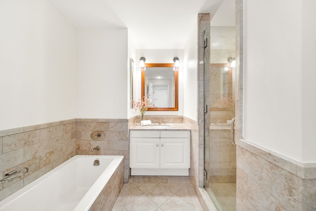 1 Avery Street, Unit 24D Boston, MA 02111 - Photo 12 of 16 a bathroom with a tub sink and mirror