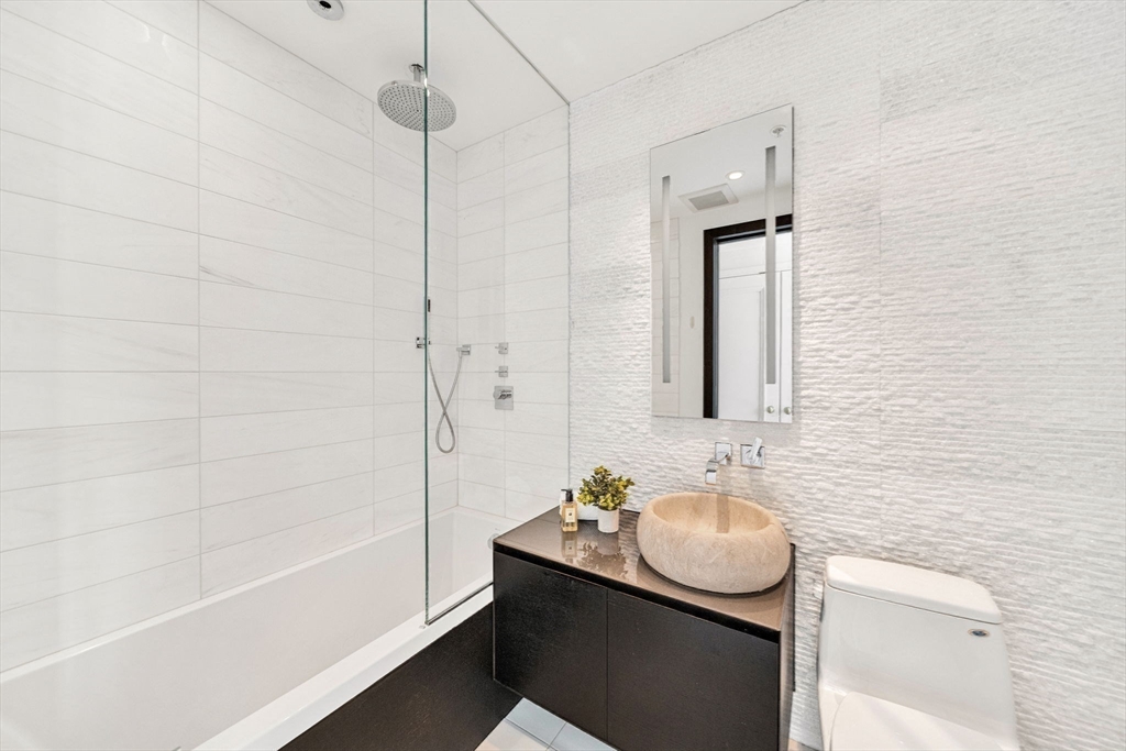 1 Avery Street, Unit 24D Boston, MA 02111 - Photo 14 of 16 a bathroom with a sink and a mirror