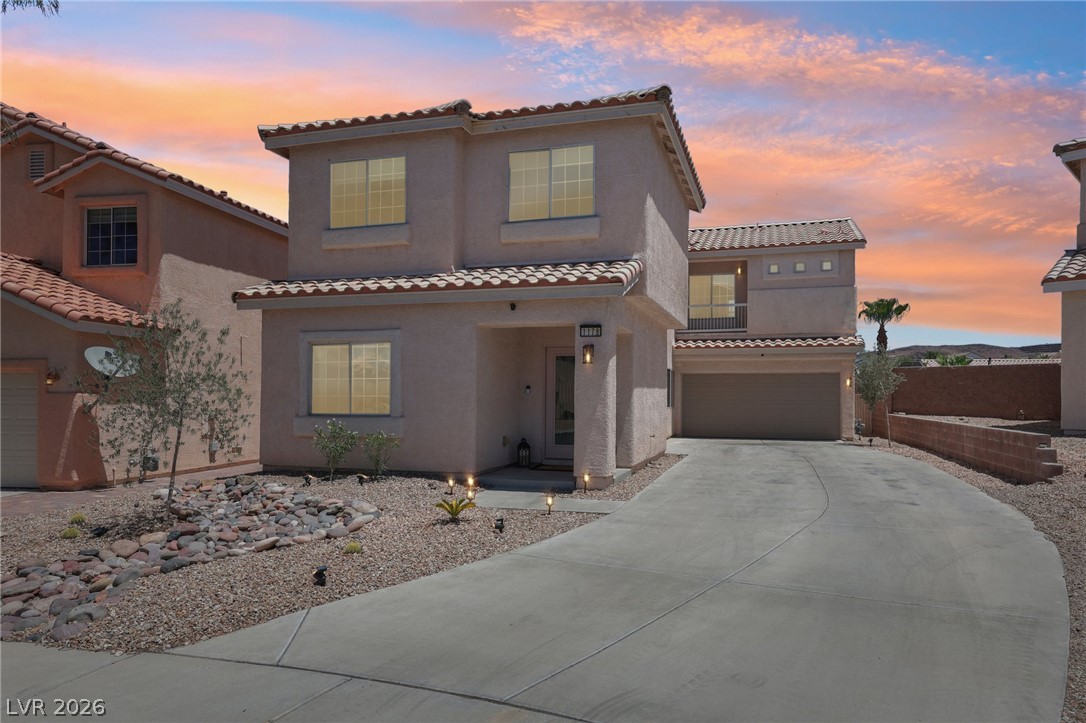 1176 Butternut Ranch Court Henderson, NV 89052 - Photo 1 of 60 A well-maintained concrete driveway leads to this charming desert dwelling under a painted sky.