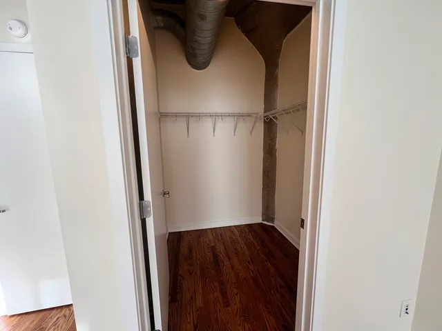 a view of walk in closet with wooden floor