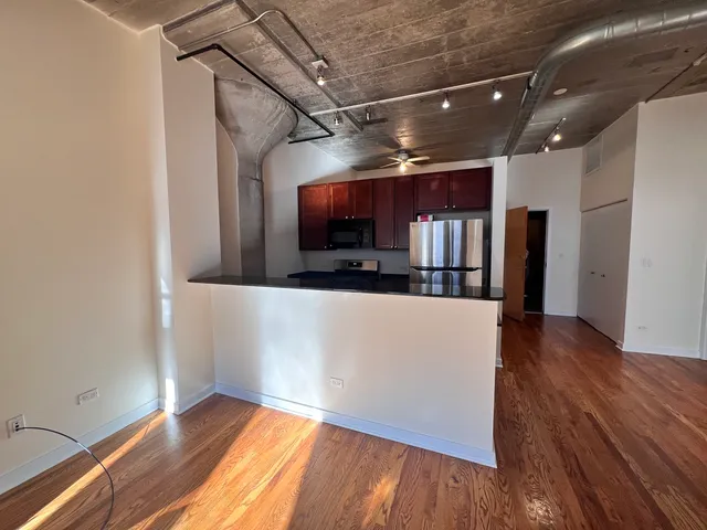 a view of a room with wooden floor and a kitchen