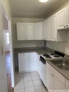 a kitchen with granite countertop white cabinets and black appliances