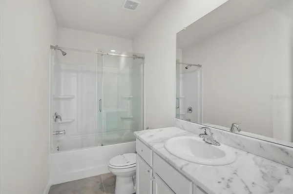 a bedroom with bed and paintings on the wall