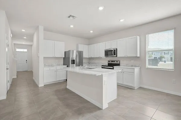 a kitchen with white cabinets and appliances