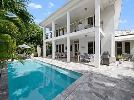 a view of a house with swimming pool and sitting area