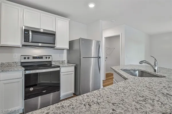 a kitchen with stainless steel appliances granite countertop a stove microwave and refrigerator