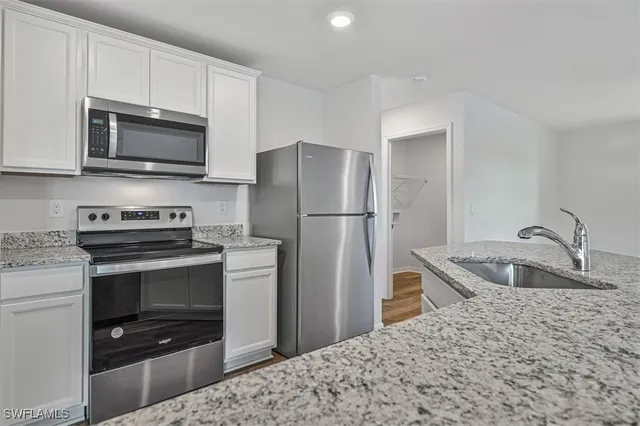 a kitchen with stainless steel appliances granite countertop a stove microwave and refrigerator