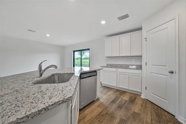 a kitchen with granite countertop a sink and cabinets