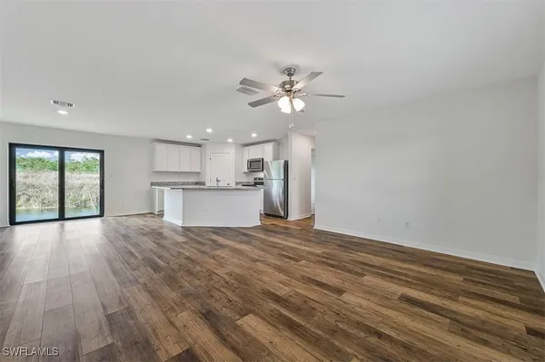 a view of a kitchen with wooden floor and a kitchen space