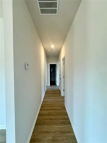 a view of a hallway with wooden floor and staircase