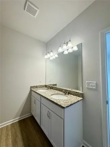 a bathroom with a granite countertop sink and a mirror