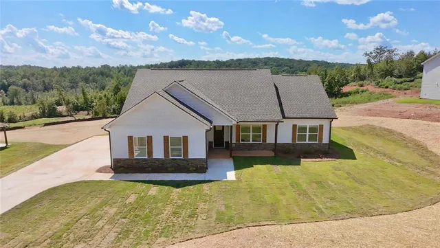 a view of house with yard and mountain view in back