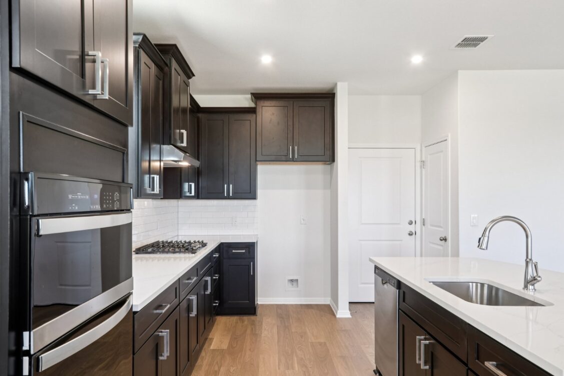 11224 Zip Cochise Way Manor, TX 78653 - Photo 18 of 40 a kitchen with kitchen island a sink appliances and cabinets