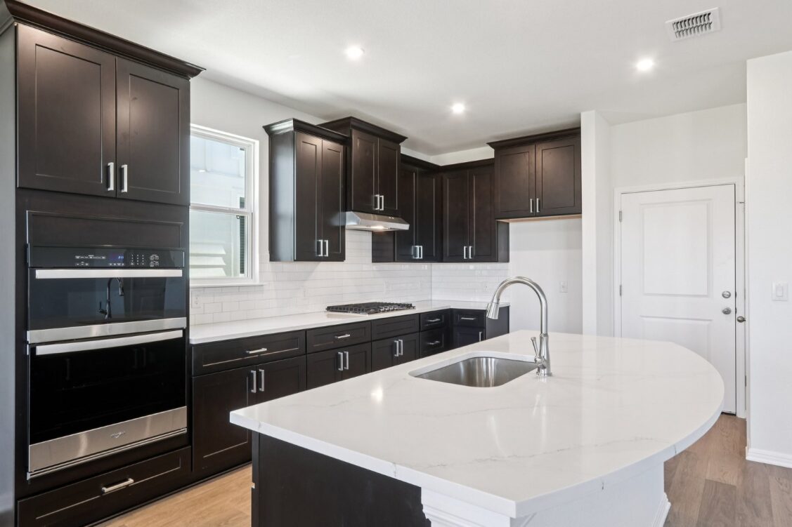 11224 Zip Cochise Way Manor, TX 78653 - Photo 19 of 40 a kitchen with stainless steel appliances a sink a stove a refrigerator and cabinets