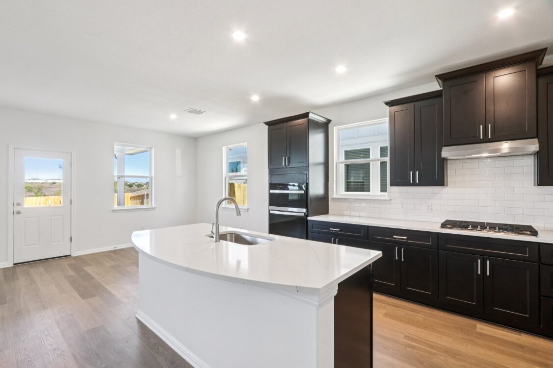 11224 Zip Cochise Way Manor, TX 78653 - Photo 20 of 40 a kitchen with a sink cabinets and wooden floor